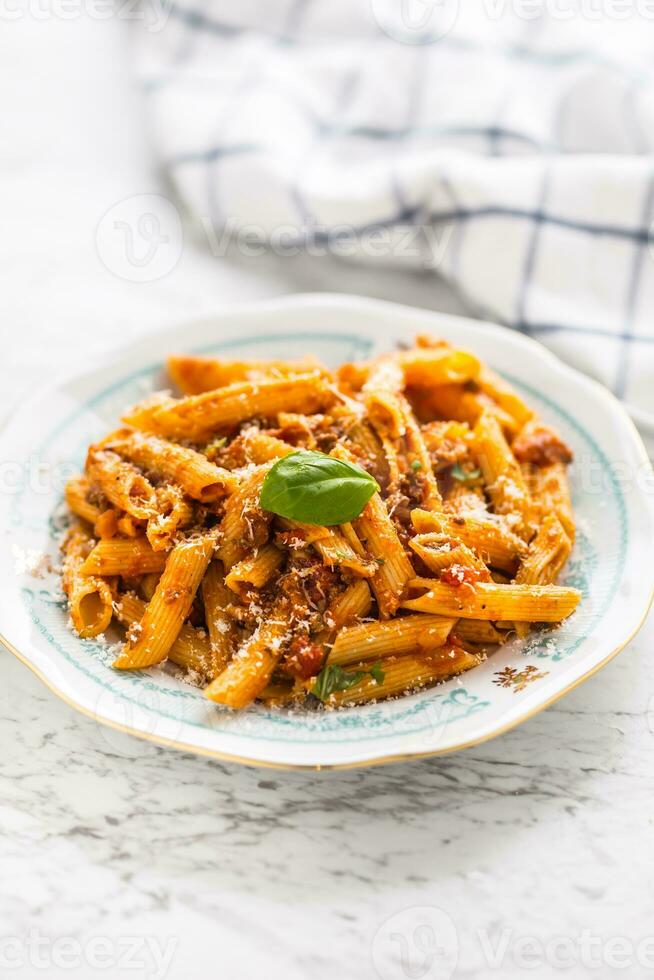 italiano cibo e pasta pene con bolognese salse su piatto foto