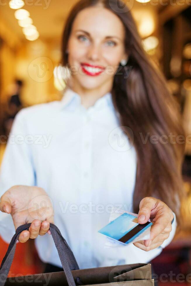 un' donna Tenere un' credito carta e shopping Borsa foto