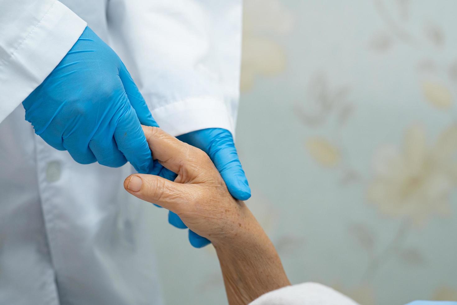 tenendosi per mano asiatica anziana o anziana signora anziana paziente con amore, cura, aiuto, incoraggiamento ed empatia nel reparto ospedaliero di cura foto