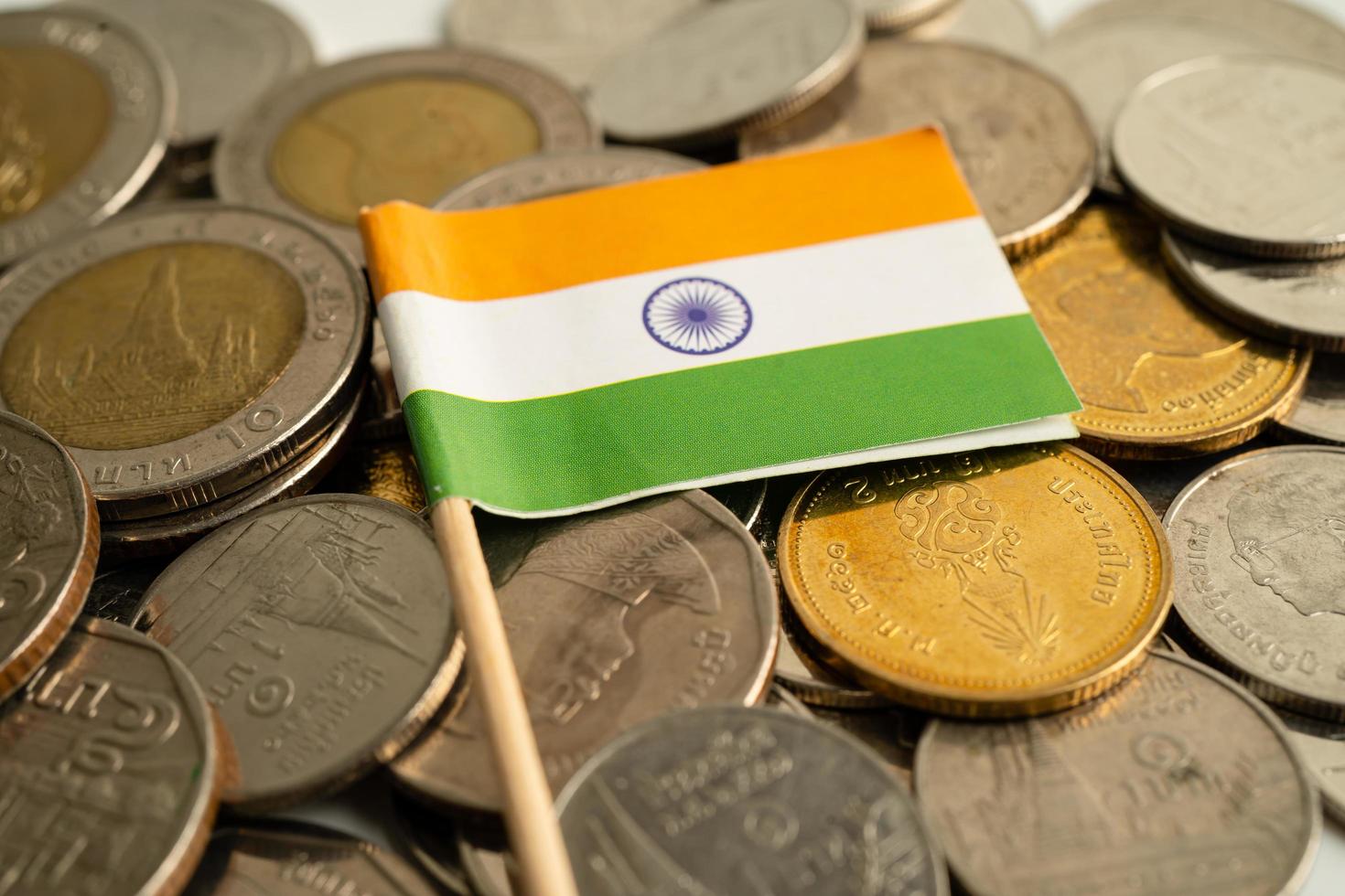 pila di monete con bandiera dell'india su sfondo bianco. bandiera su sfondo bianco. foto