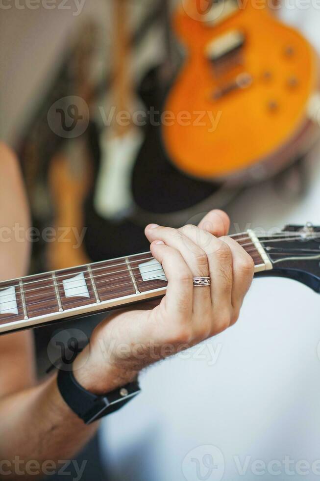 un' persona giocando un elettrico chitarra nel davanti di un' chitarra cremagliera foto