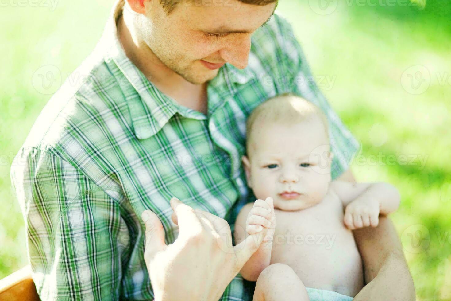 un' uomo e il suo bambino siamo seduta nel il erba foto
