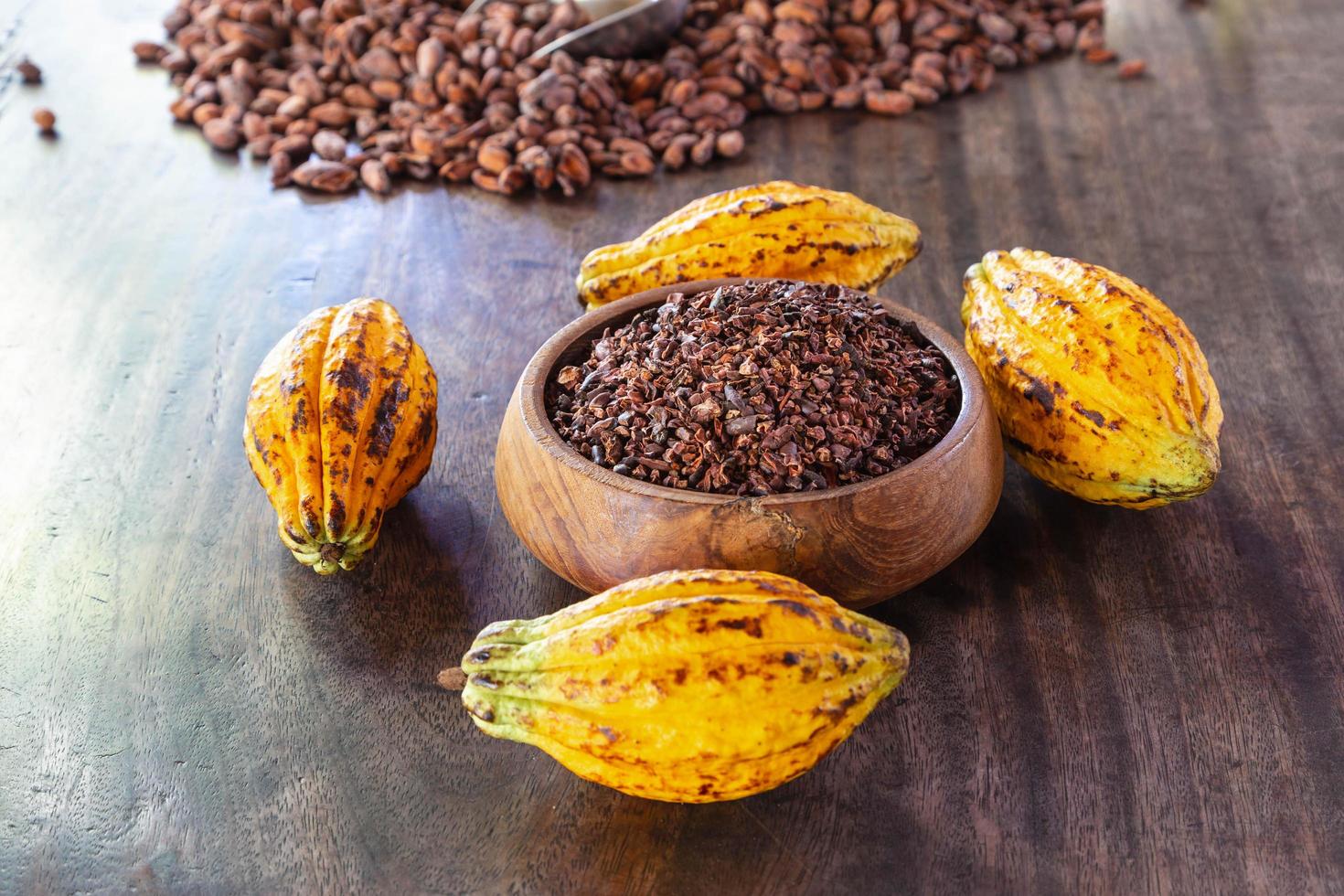 pennini di cacao e frutta di cacao su tavola di legno foto