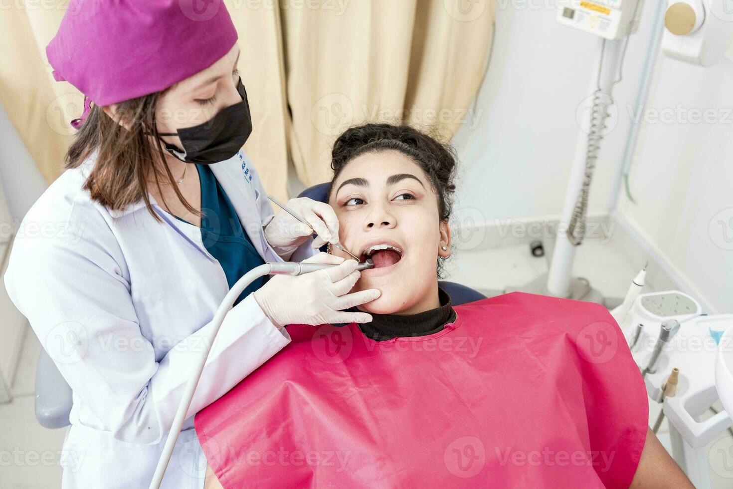 un' dentista pulizia un' paziente bocca con un' trapano. stomatologo pulizia un' del paziente denti, avvicinamento di un' stomatologo pulizia un' donna di denti, stomatologo pulizia carie con trapano foto