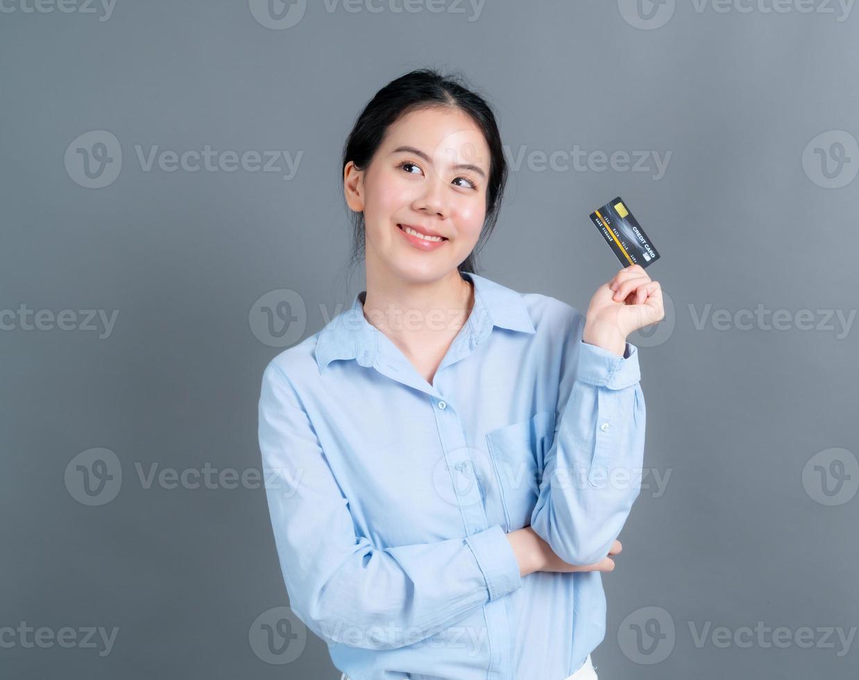 ritratto di una bella giovane donna asiatica che mostra la carta di credito credit foto