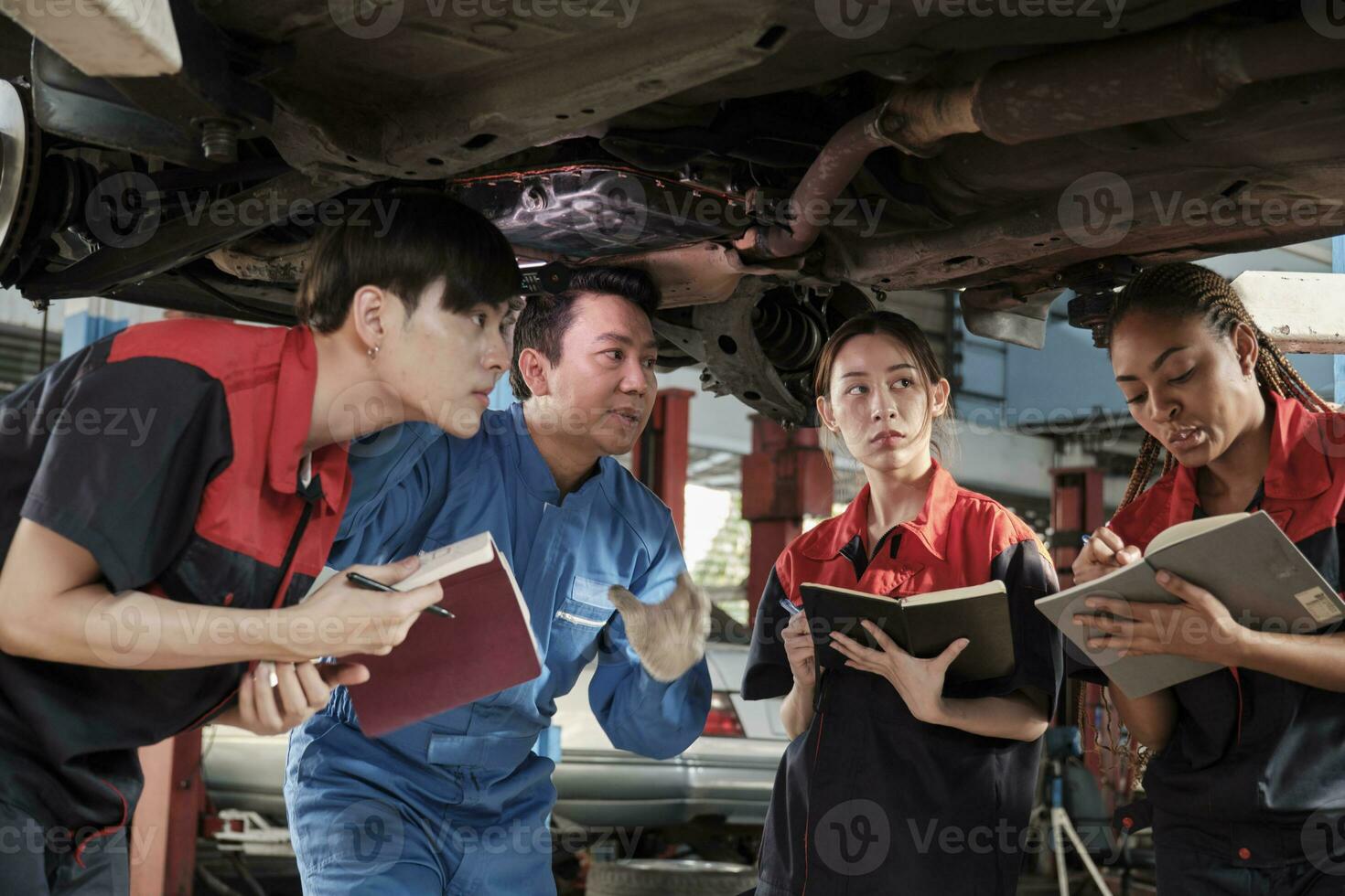 specialista conferenza, maschio supervisore ingegnere descrivere benzina settore automobilistico fissaggio con meccanico lavoratore personale squadre per riparazione opera a auto servizio box auto e Manutenzione lavori nel automobile industria. foto