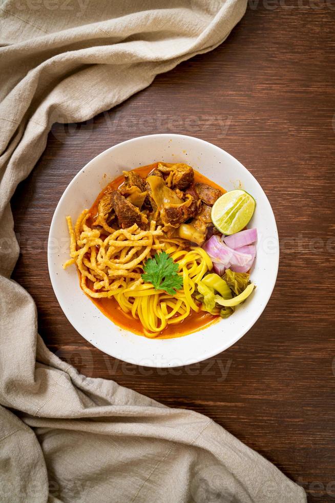 zuppa di noodle al curry del nord della Thailandia con maiale brasato foto