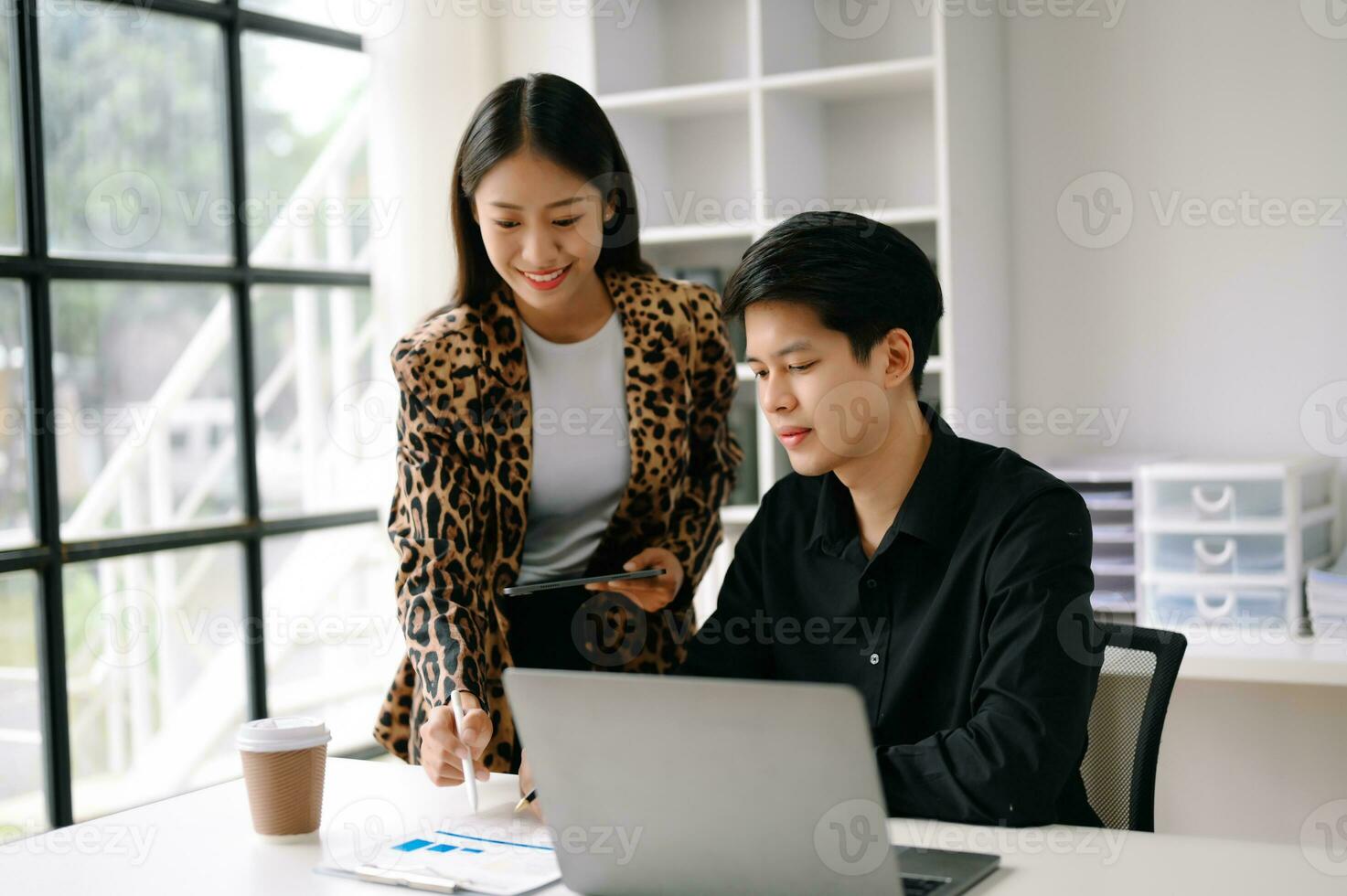 Due asiatico attività commerciale uomo e donna lavoratori parlando su il smartphone e utilizzando il computer portatile professionisti nel lavoro di squadra finanza, marketing, e successo foto