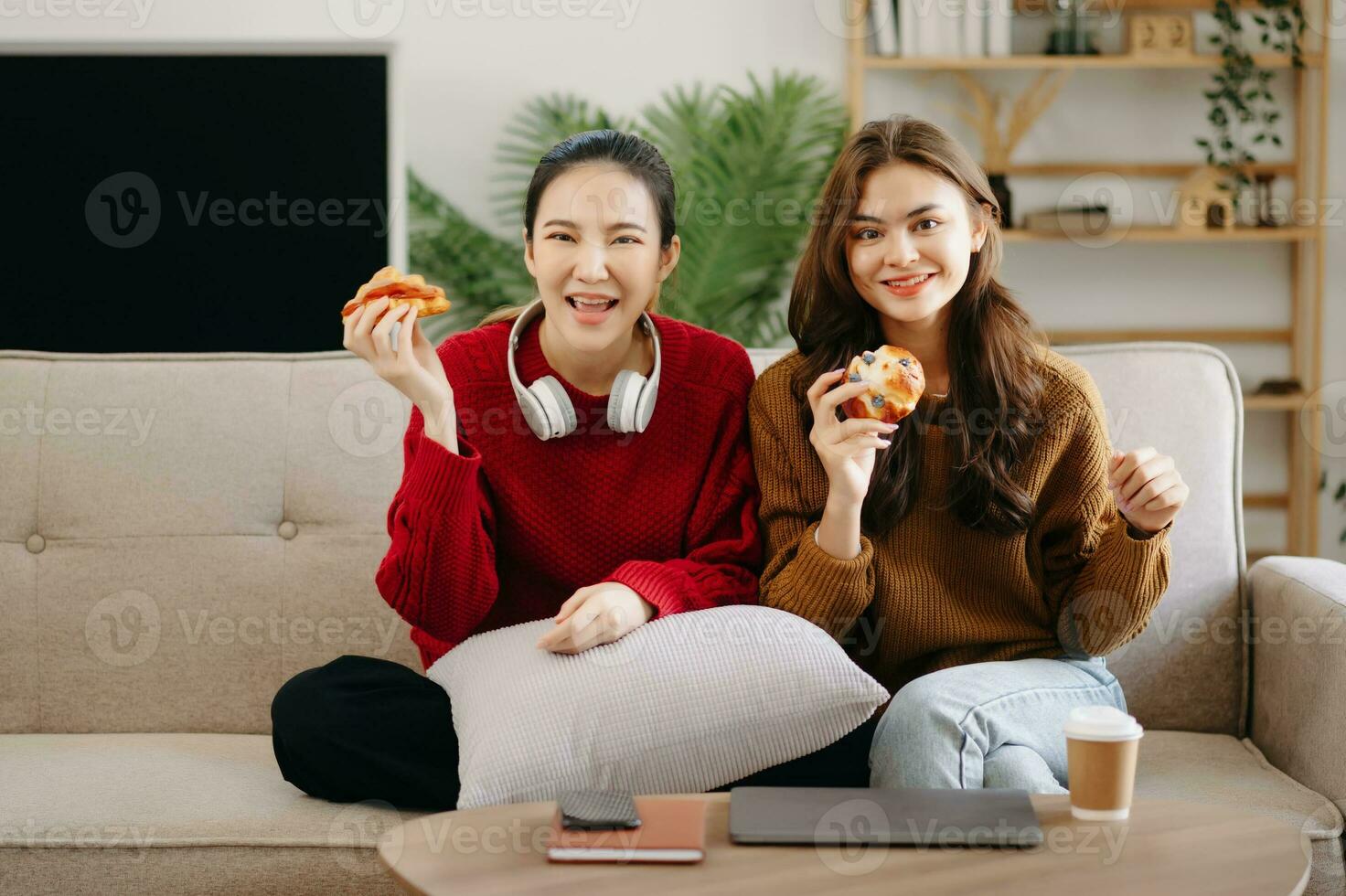 Due asiatico bellezza sorridente giovane donne seduta su divano attraente casuale ragazza sentire contento e rilassati, avendo divertimento orologio commedia video su tv nel Casa. attività stili di vita concetto foto