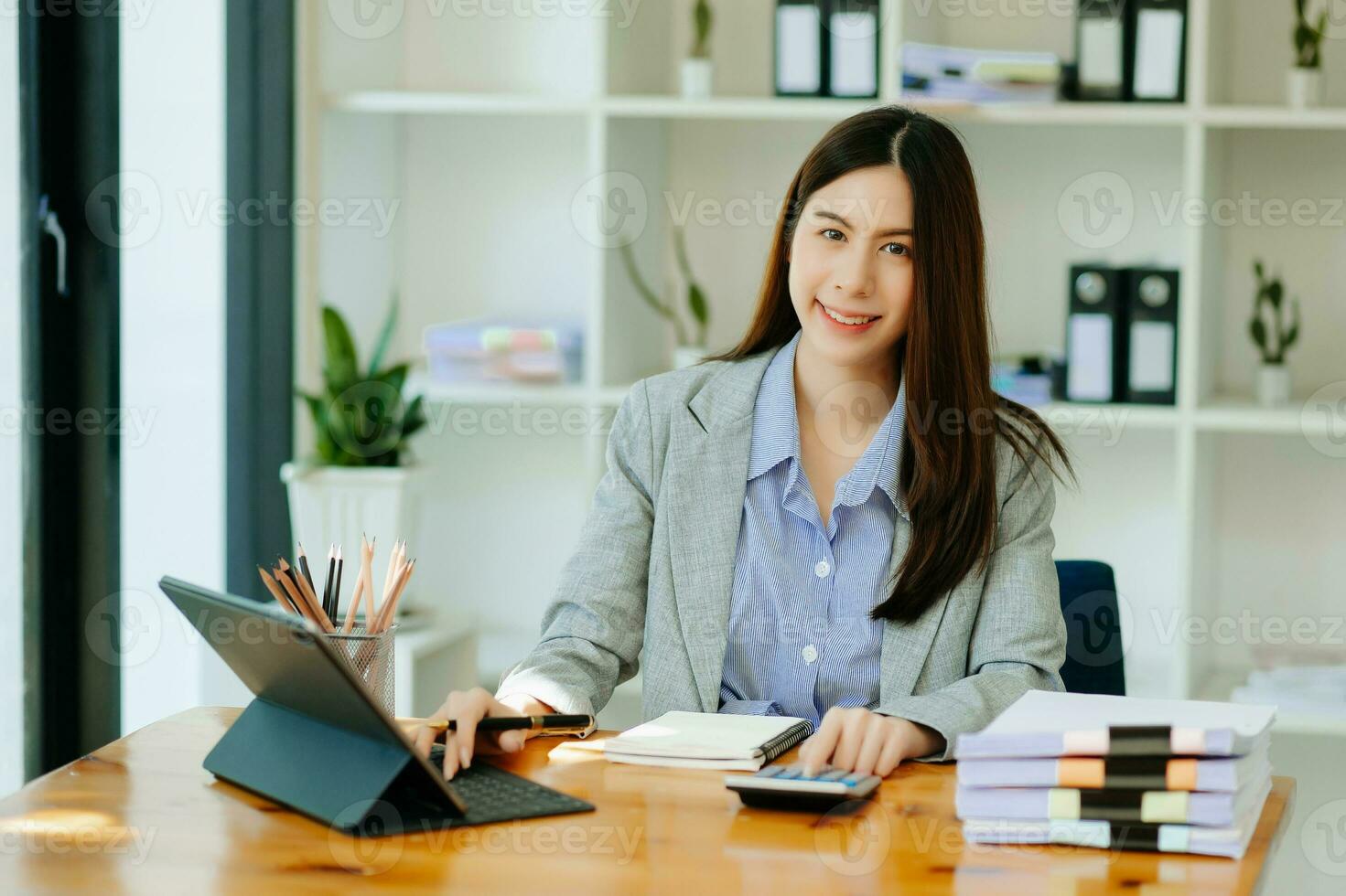 asiatico donna d'affari Lavorando nel il ufficio con Lavorando bloc notes, tavoletta e il computer portatile documenti foto