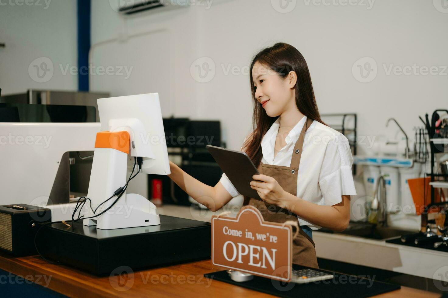 asiatico femmina caffè negozio proprietario nel un' caffè negozio foto