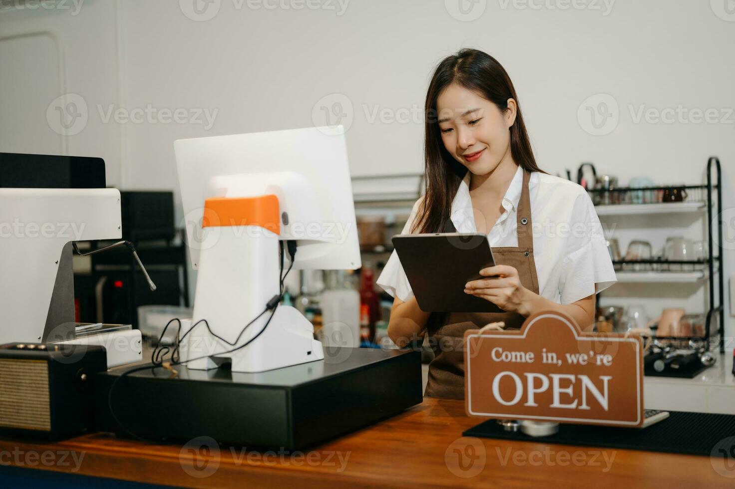 asiatico femmina caffè negozio proprietario nel un' caffè negozio foto
