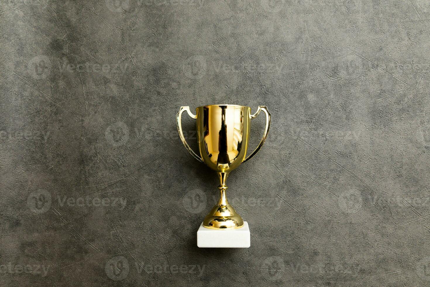 semplicemente piatto posare design vincitore o campione oro trofeo tazza su calcestruzzo pietra grigio sfondo. vittoria primo posto di concorrenza. vincente o successo concetto. superiore Visualizza copia spazio. foto