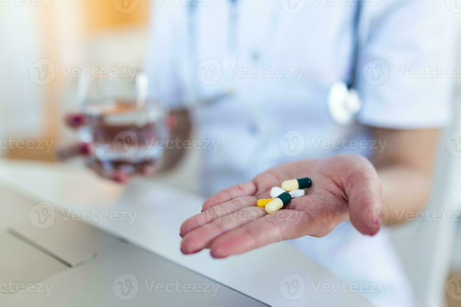 femmina medico avendo in linea terapia con sua del paziente, dando loro consigli mentre Tenere un' pillola e bicchiere di acqua nel sua mani foto