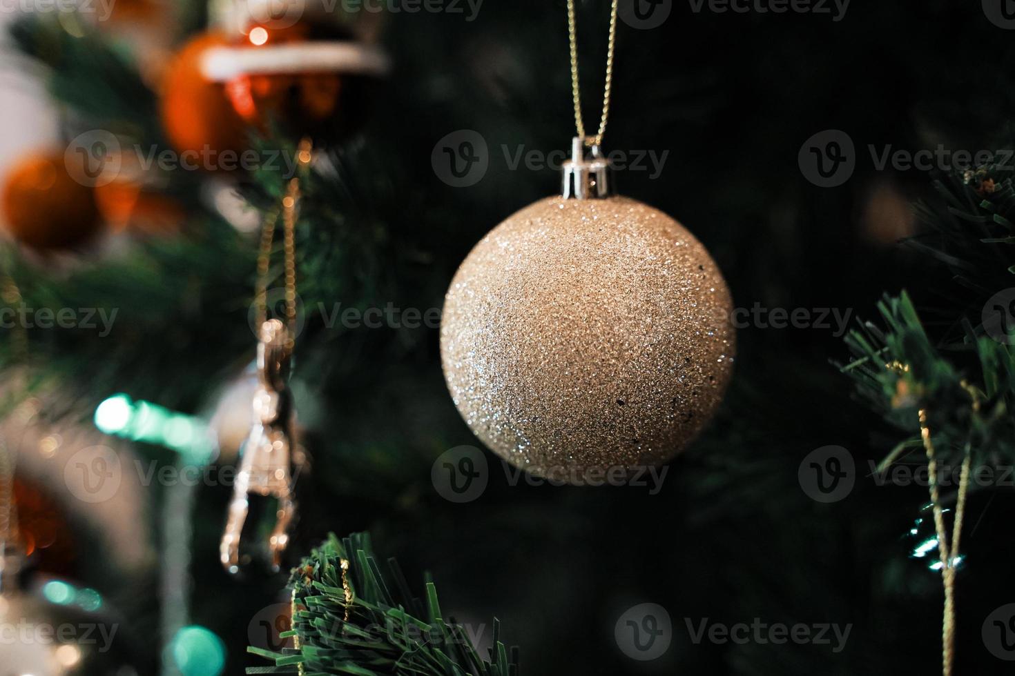 palle di natale dorate su un albero di natale verde, primo piano. decorazioni di natale e capodanno. foto