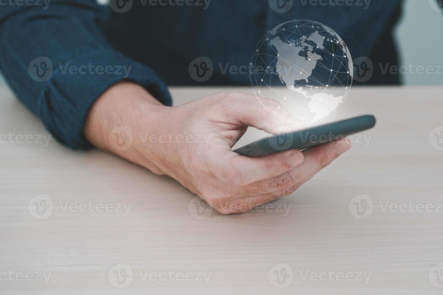 mano che tiene il telefono cellulare con connessione di rete globale, mano uomo con terra virtuale su sfondo sfocato. foto