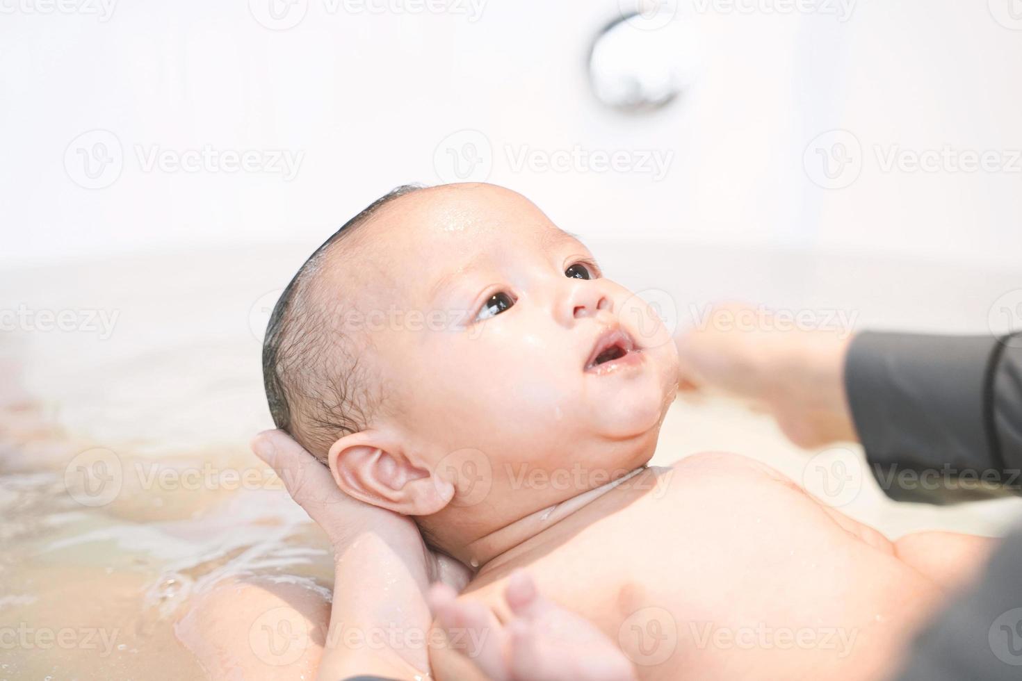 la mamma sta facendo il bagno a suo figlio nella vasca idromassaggio. foto