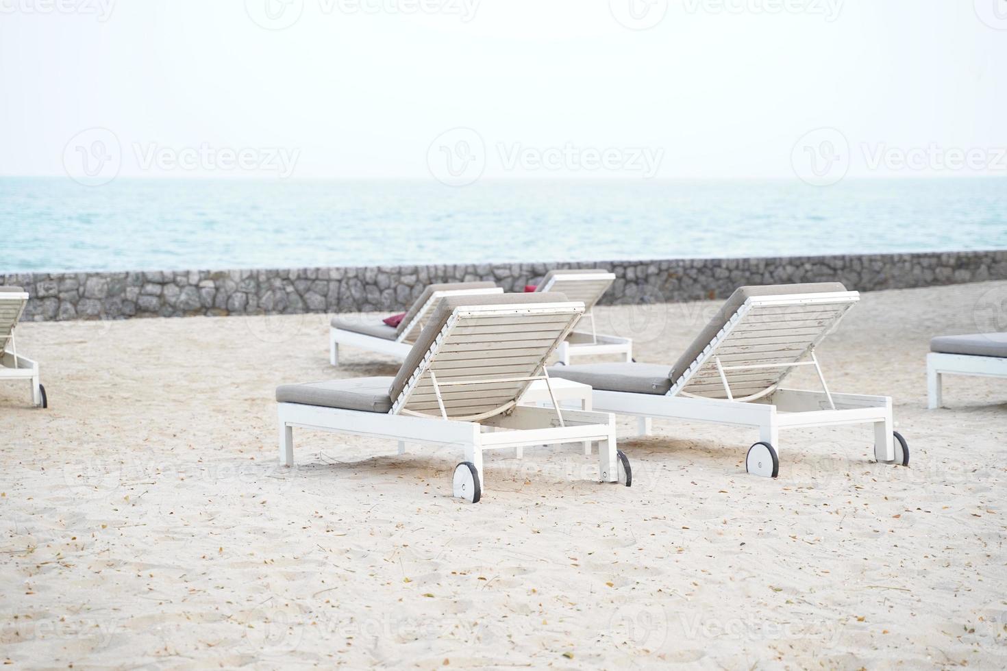 lettini bianchi sulla spiaggia. vacanze vacanze estive sfondo. foto