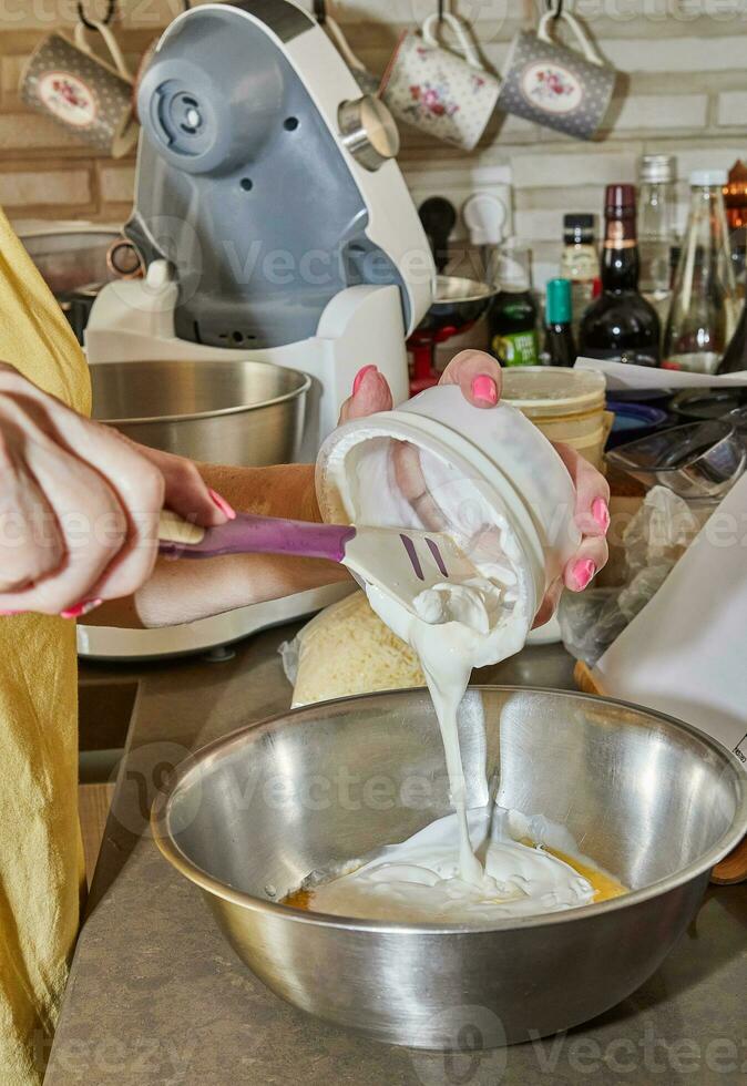 capocuoco Aggiunge creme fraiche per un' ciotola di torta ingredienti foto