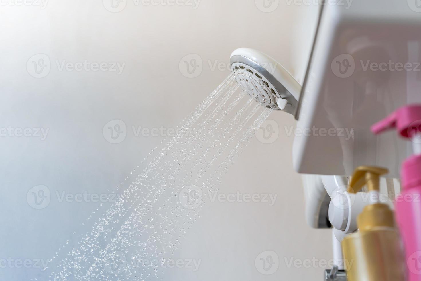 primo piano dell'acqua che scorre dalla doccia in bagno foto