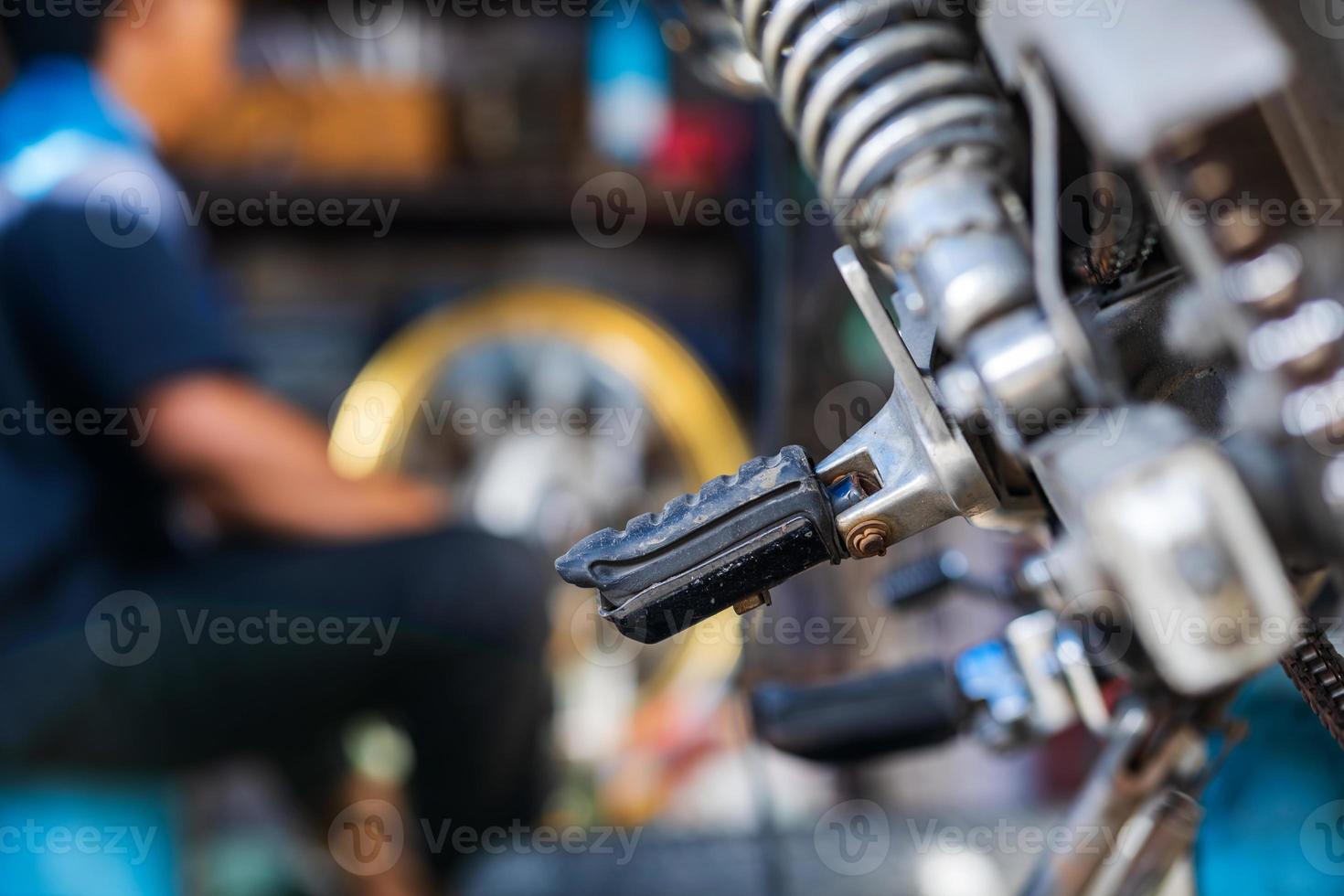 meccanico di automobili che ripara motocicletta in un'officina di riparazione di biciclette foto