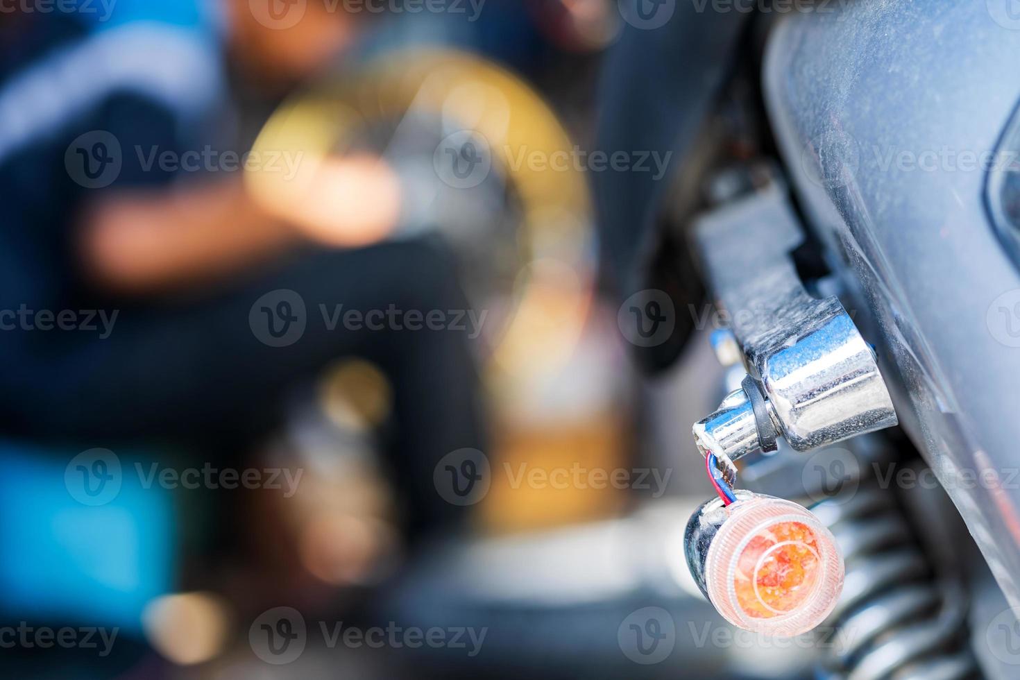 meccanico di automobili che ripara motocicletta in un'officina di riparazione di biciclette foto