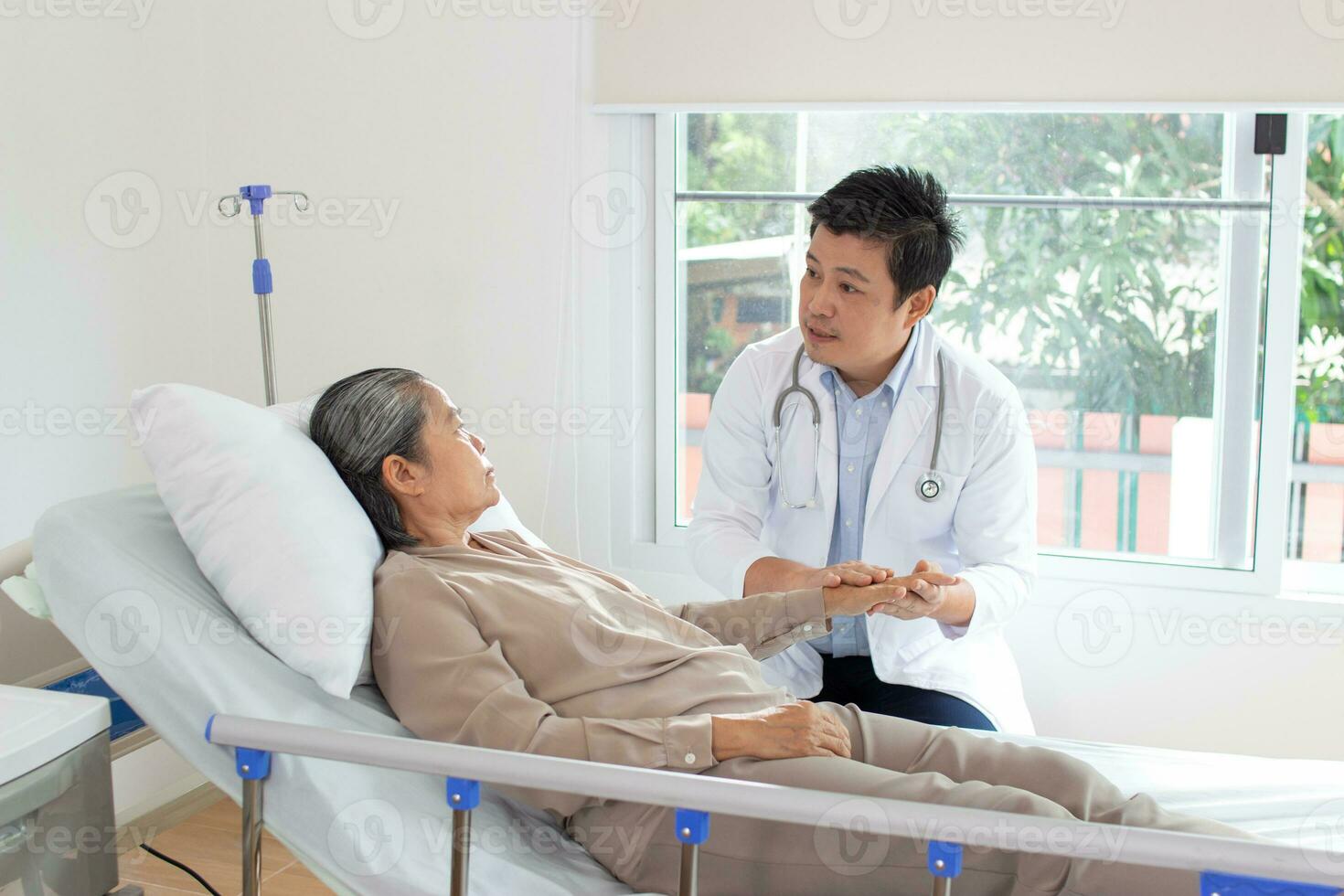 maschio medico discutere al di sopra di medico disco con anziano donna nel Ospedale. foto