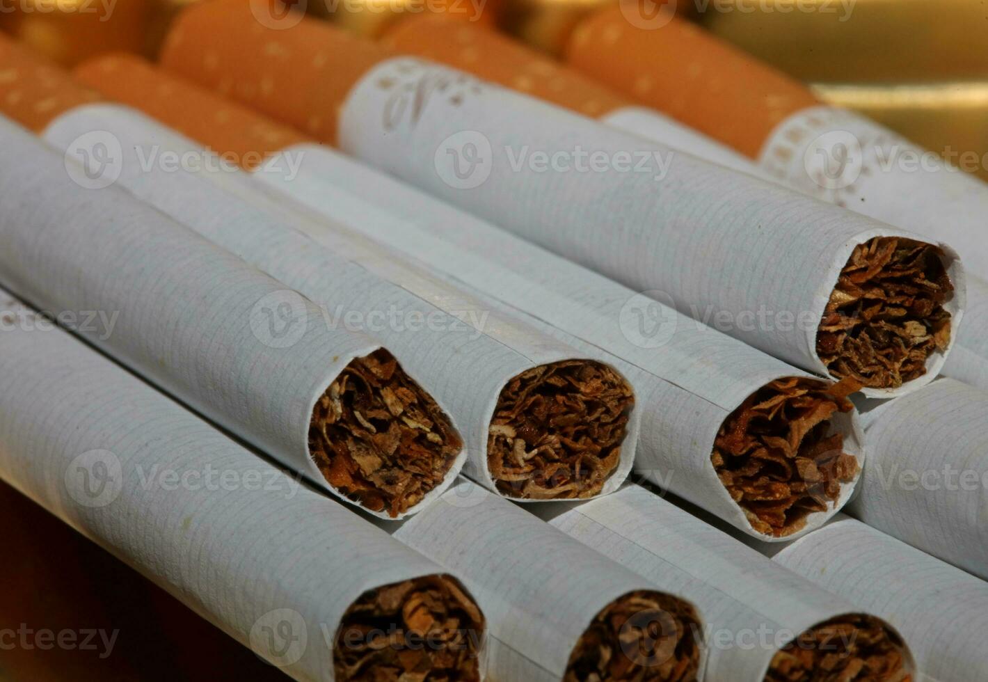 molti sigarette nel sfondo vicino su di un' rotolo tabacco nel carta con filtro concetto Immagine di parecchi commercialmente fatto sigarette mucchio non fumo campagna tabacco uccide alto neonicotinoidi Pericolo foto