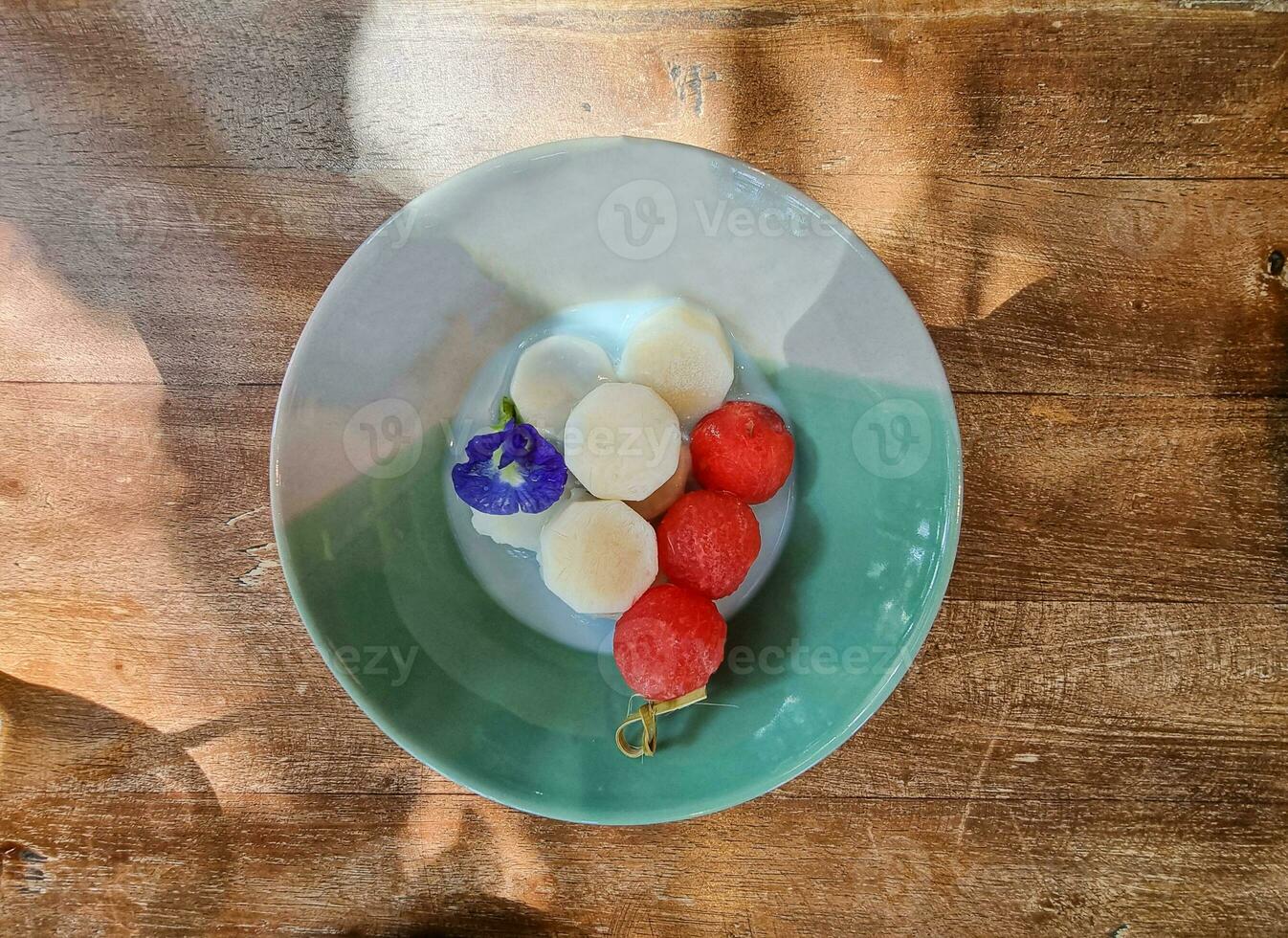 dolce fatti in casa dolce cerchio rosso anguria palla e Noce di cocco ghiaccio crema decorazione con farfalla pisello fiori foto