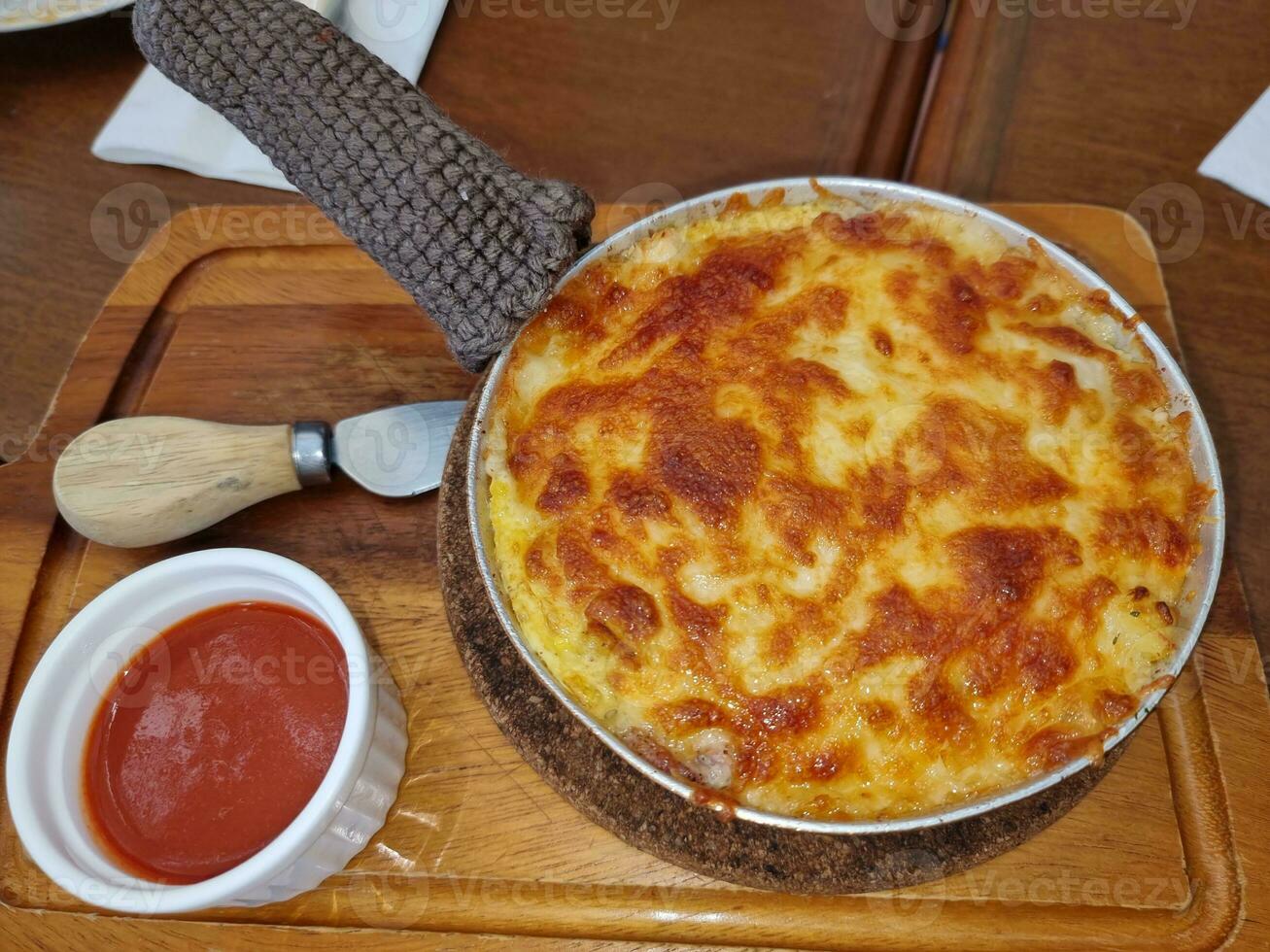 Lasagna caldo griglia nel cerchio padella su di legno piatto servire con pomodoro salsa. fatti in casa Pasticcino cucinando cena foto