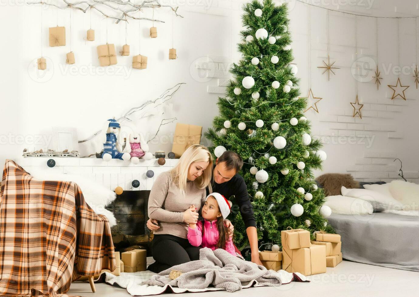 nuovo anno. Natale. famiglia. giovane genitori e loro poco figlia nel Santa cappelli siamo la spesa tempo insieme vicino il natale albero a casa foto