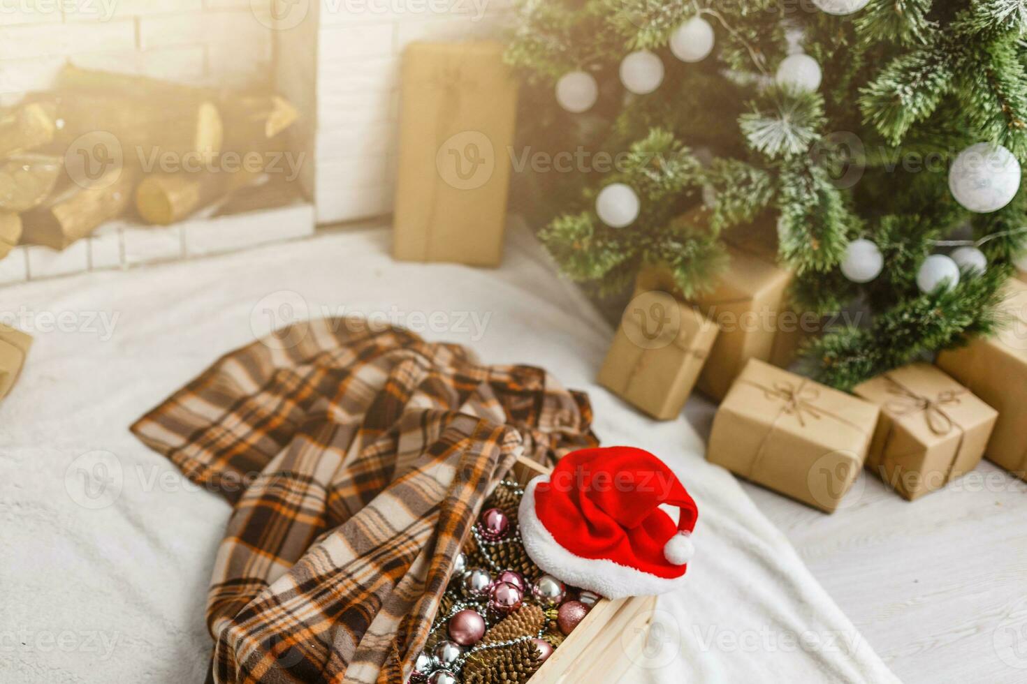 Natale i regali vicino il Natale albero e Santa cappello foto