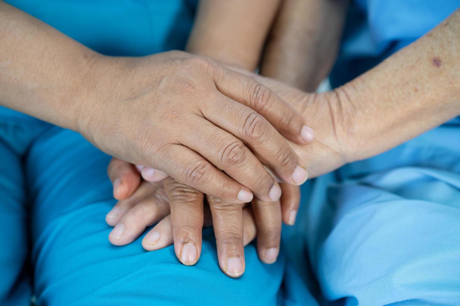 tenendosi per mano asiatica anziana o anziana signora anziana paziente con amore, cura, incoraggiamento ed empatia nel reparto ospedaliero di cura, concetto medico sano e forte foto