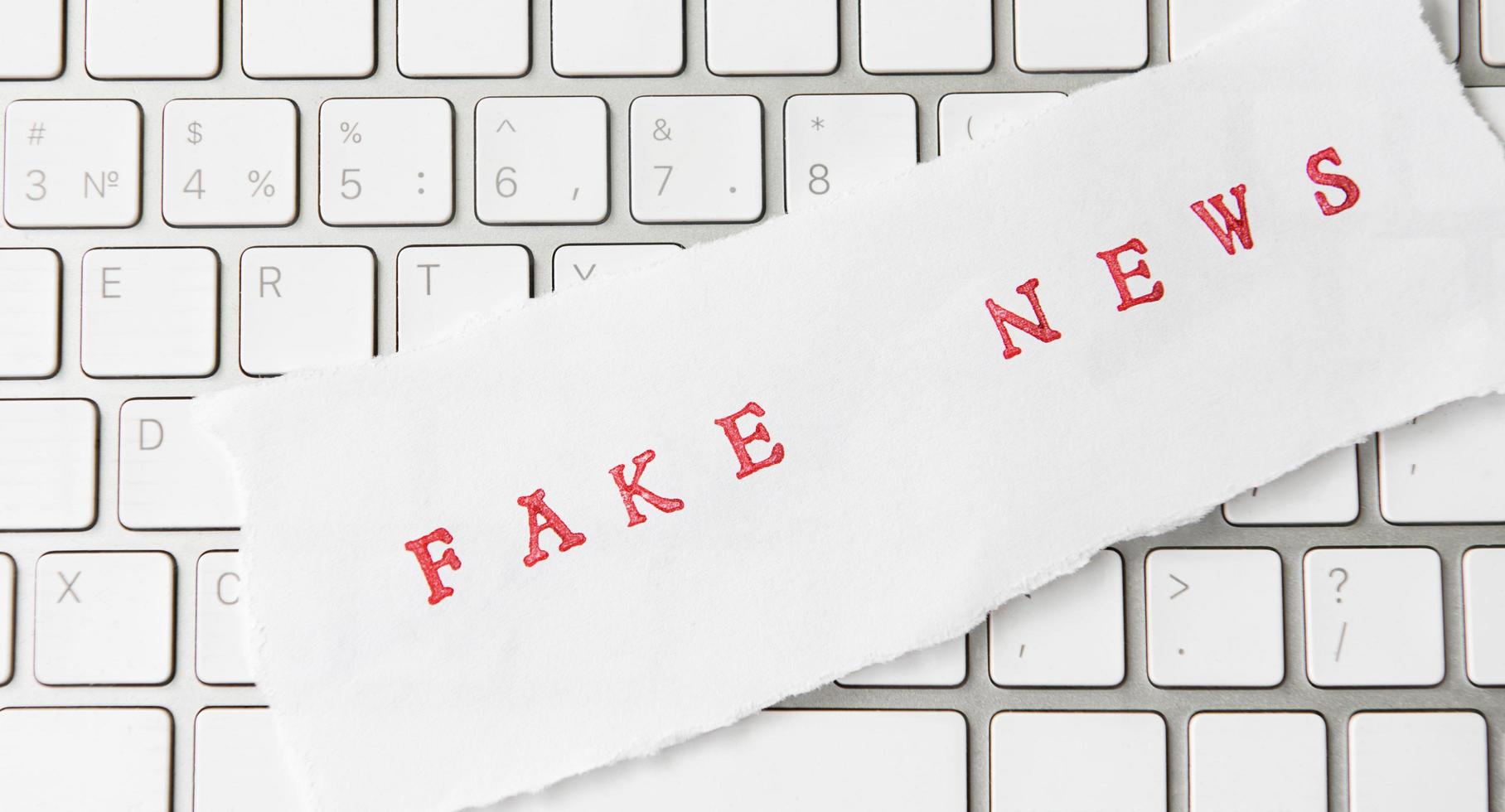 parole fake news scritte su carta strappata foto