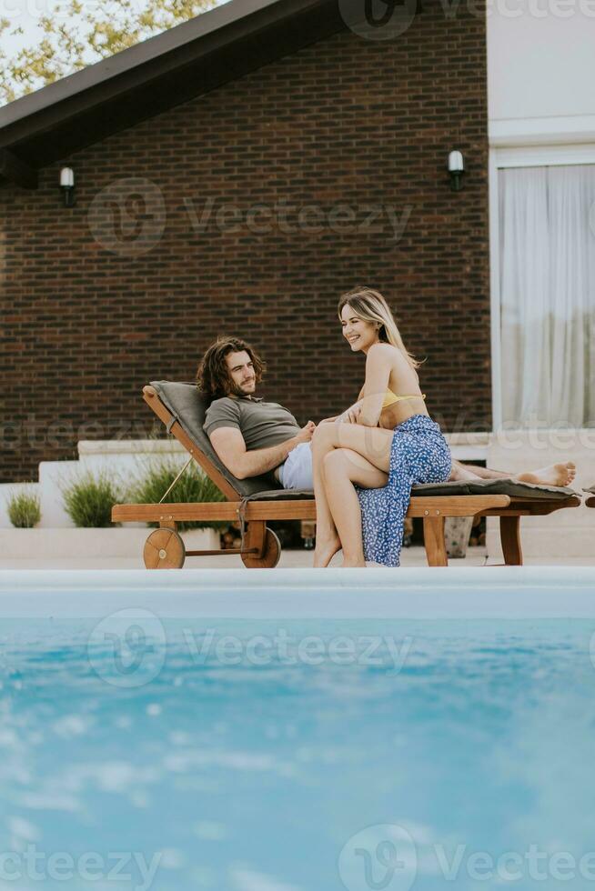 giovane coppia rilassante di il nuoto piscina nel il Casa Giardino dietro la casa foto