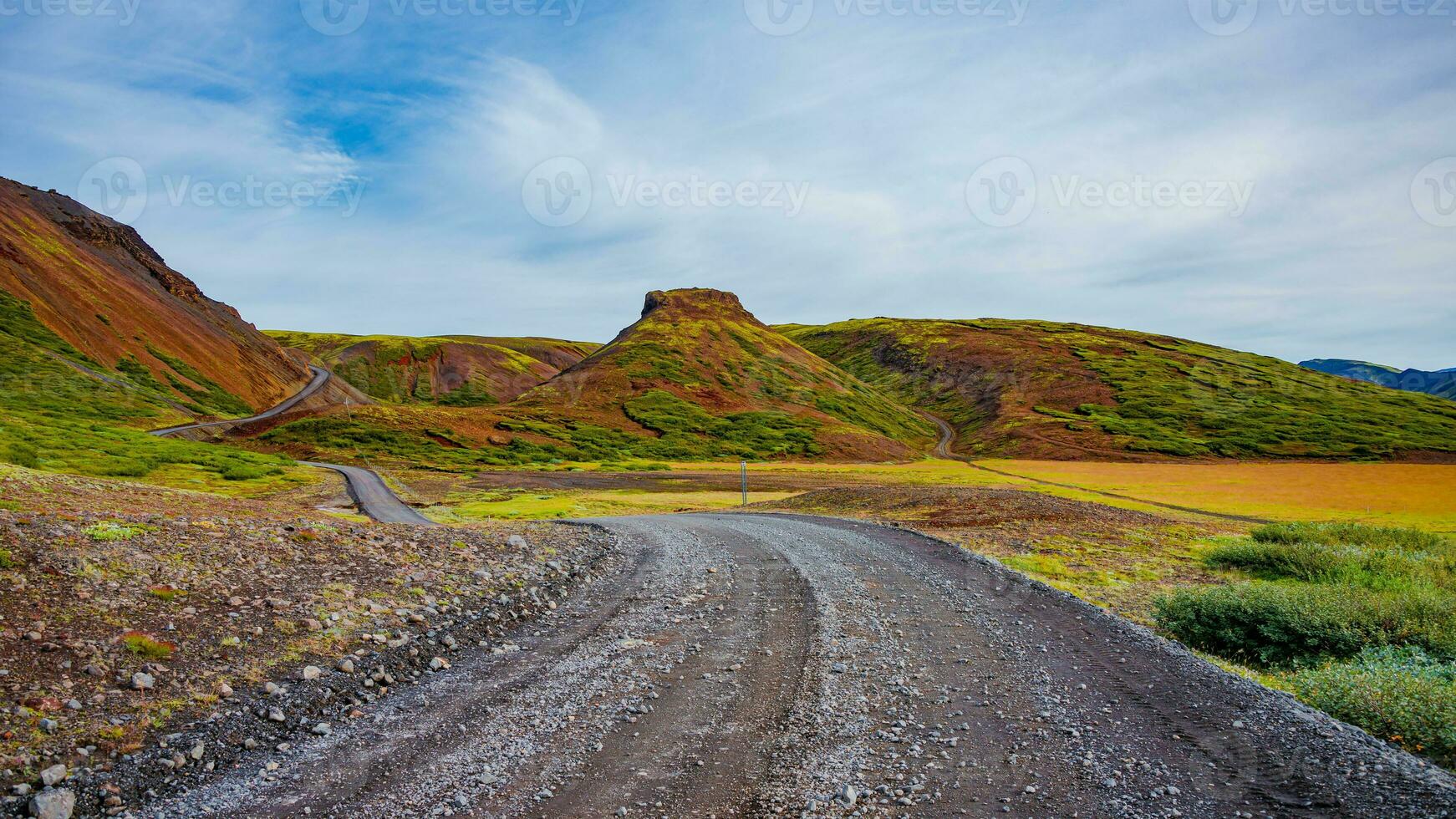 panoramico al di sopra di islandese colorato e selvaggio vulcanico paesaggio e ghiaia via strada traccia a estate e blu cielo, Islanda foto