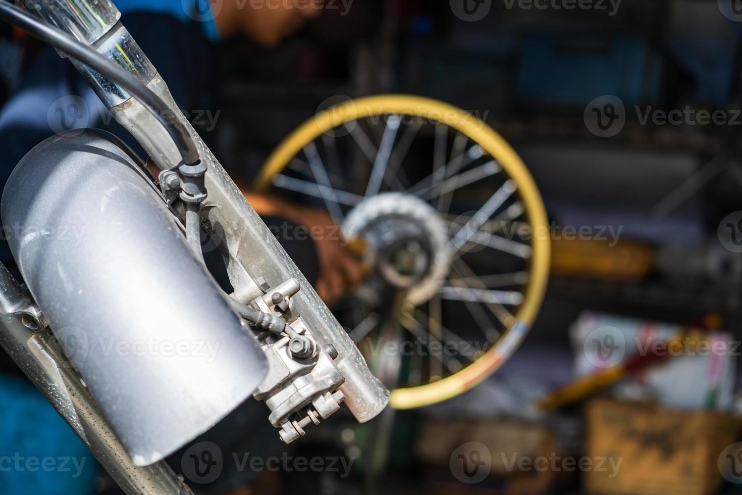 meccanico di automobili che ripara motocicletta in un'officina di riparazione di biciclette foto