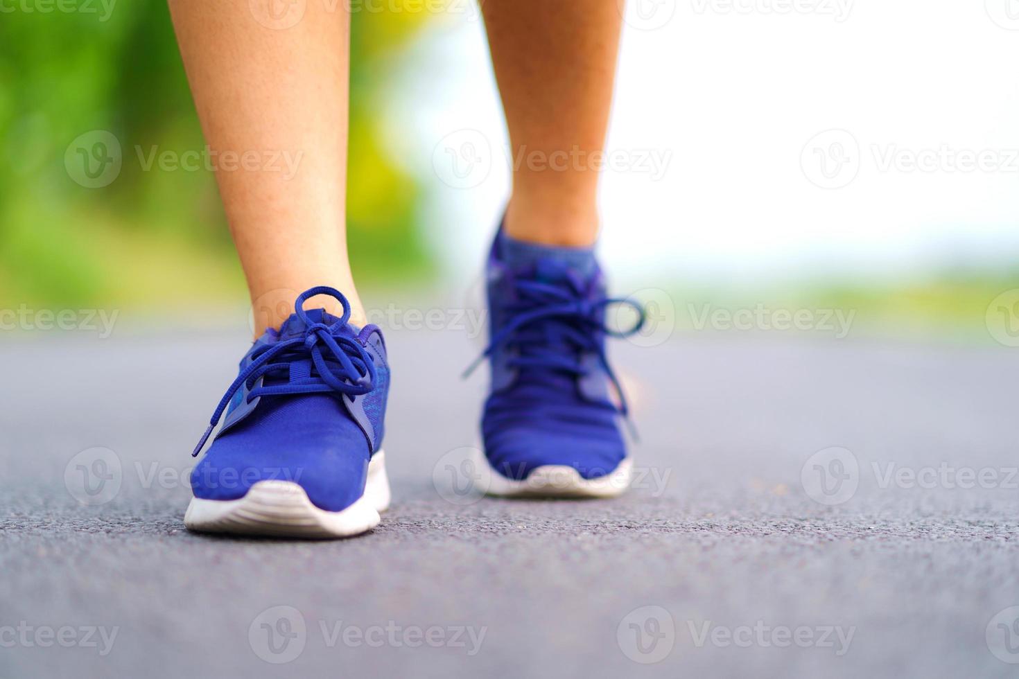 gambe di donna che camminano nel parco, corridore femminile che corre sulla strada fuori foto