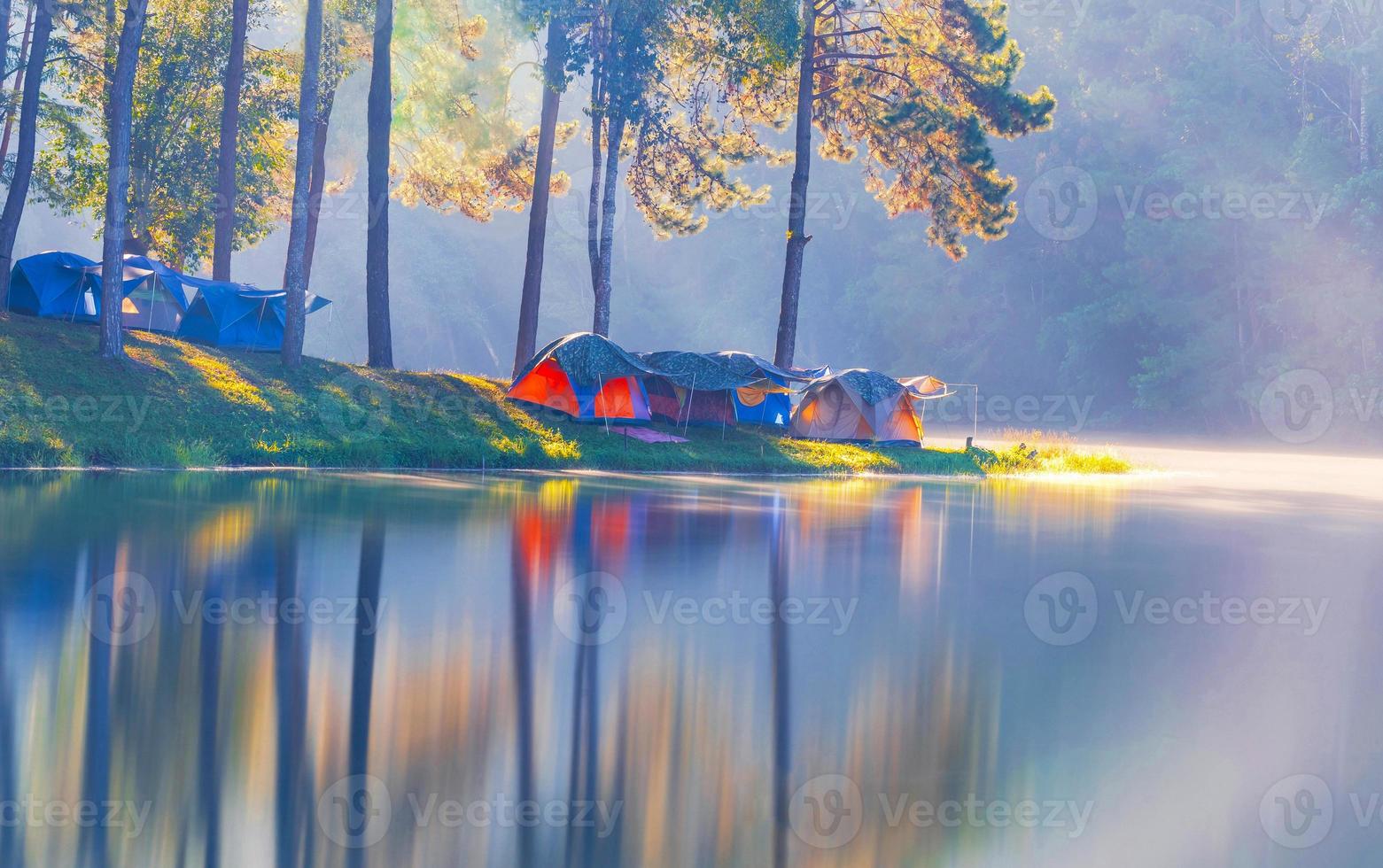 avventure campeggio turismo e tenda sotto la foresta di pini con riflesso sull'acqua al mattino a pang-ung, mae hong son, thailandia foto