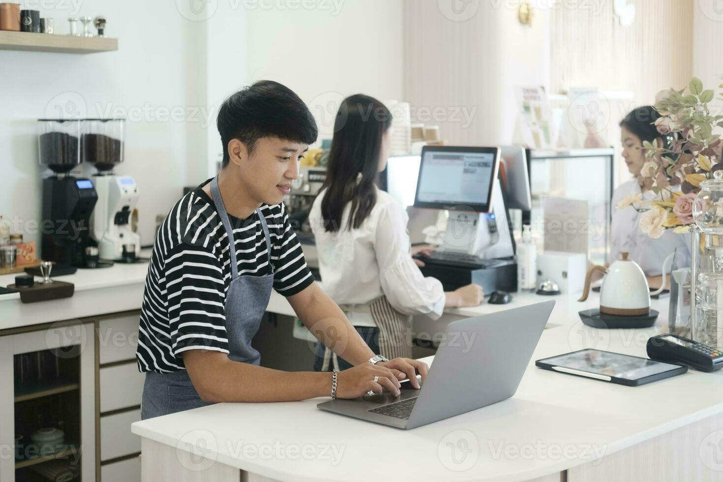 Due giovane manager o negozio proprietari avendo alcuni discussione Lavorando su un' il computer portatile a il contatore di il negozio o bar. foto