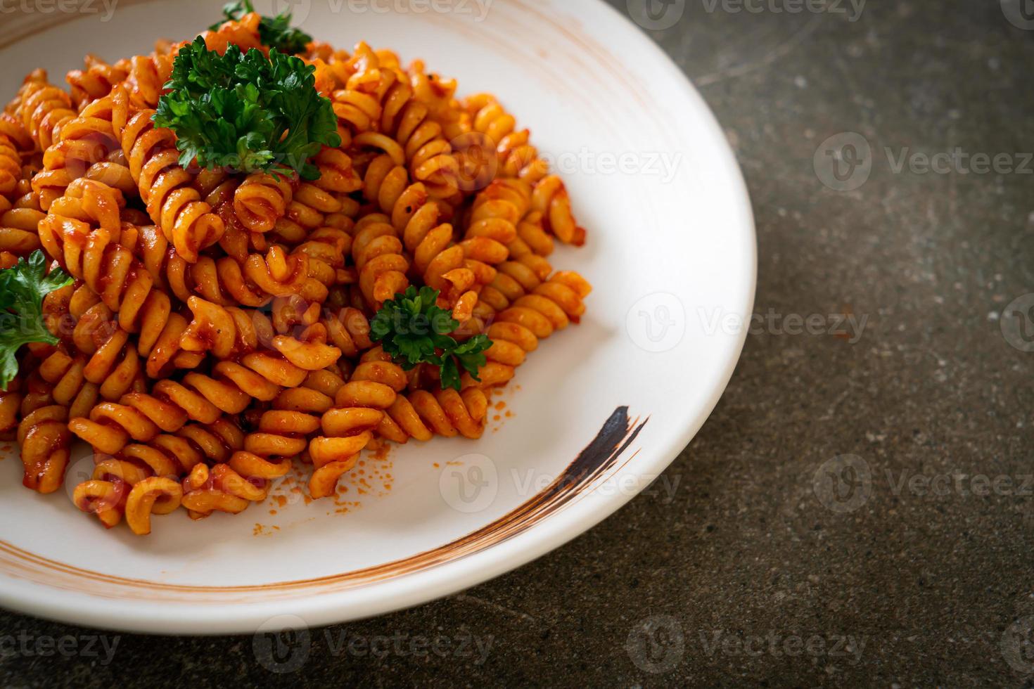 pasta a spirale o spirali con salsa di pomodoro e salsiccia - stile italiano foto