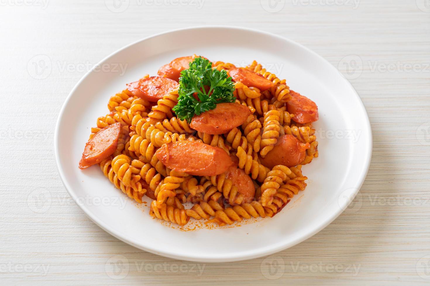 pasta a spirale o spirali con salsa di pomodoro e salsiccia - stile italiano foto