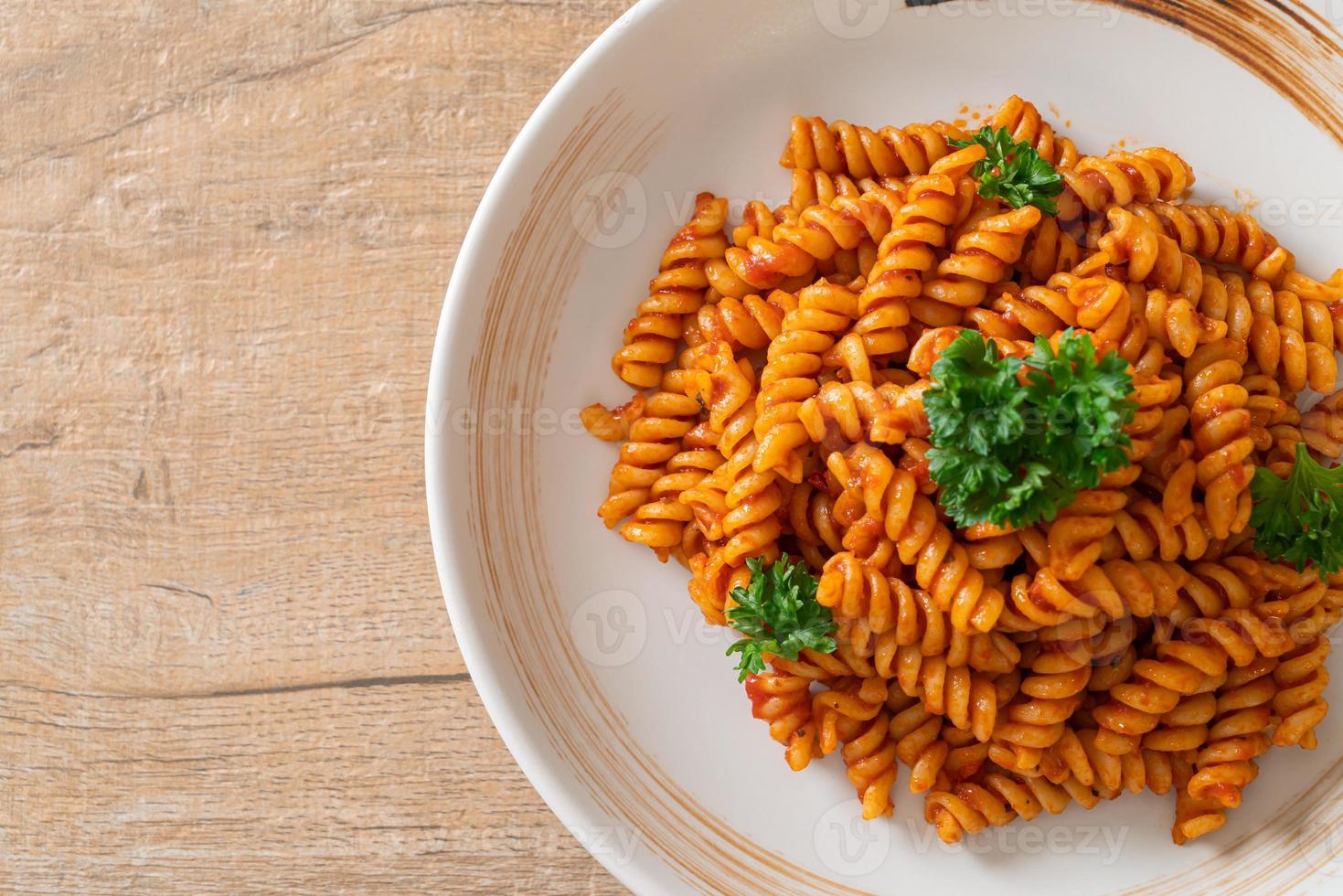 pasta a spirale o spirali con salsa di pomodoro e salsiccia - stile italiano foto