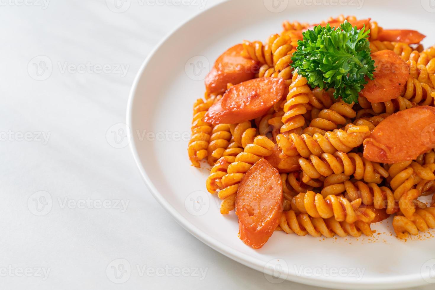 pasta a spirale o spirali con salsa di pomodoro e salsiccia - stile italiano foto