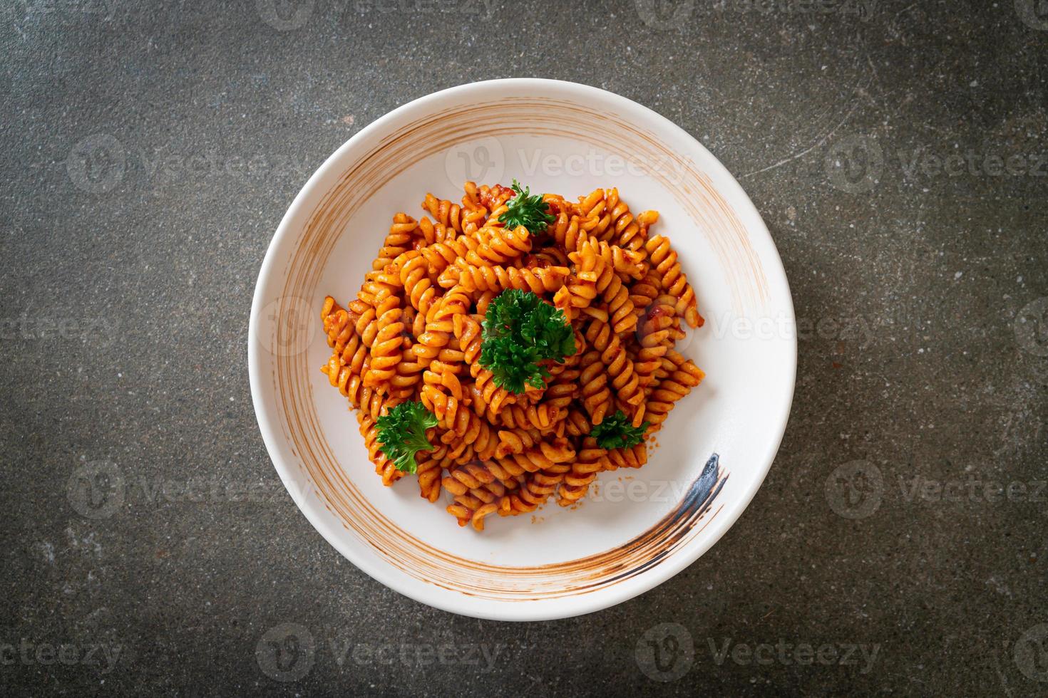 pasta a spirale o spirali con salsa di pomodoro e salsiccia - stile italiano foto