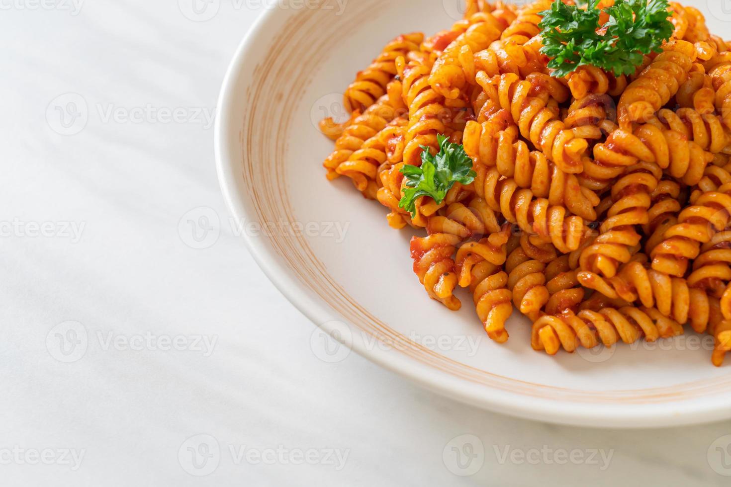 pasta a spirale o spirali con salsa di pomodoro e salsiccia - stile italiano foto