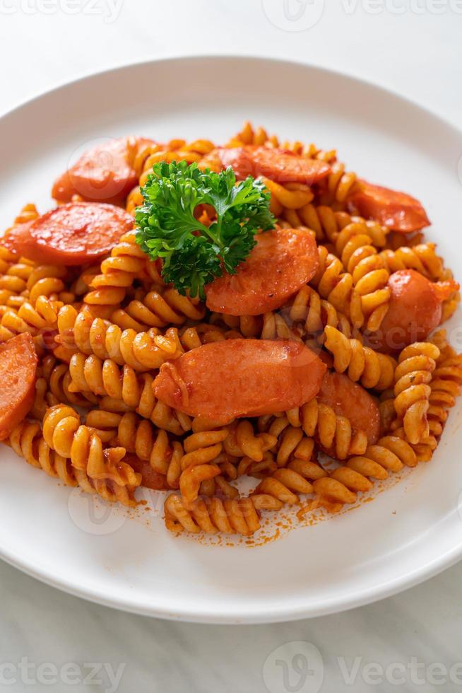 pasta a spirale o spirali con salsa di pomodoro e salsiccia - stile italiano foto