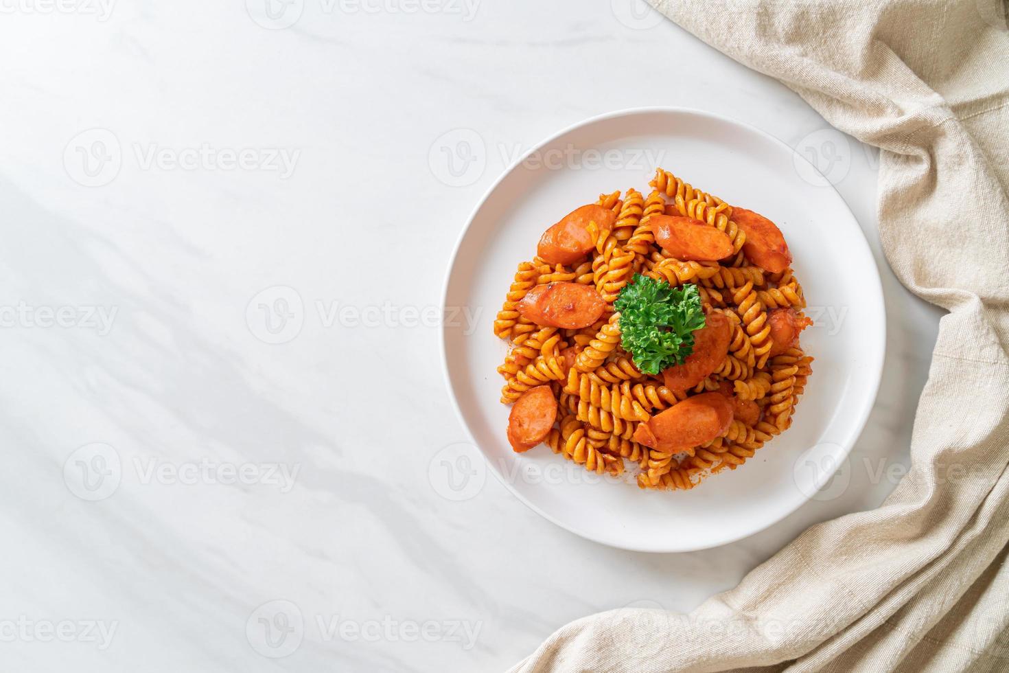 pasta a spirale o spirali con salsa di pomodoro e salsiccia - stile italiano foto