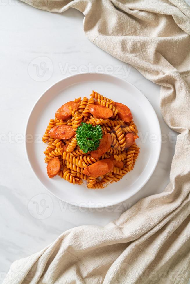 pasta a spirale o spirali con salsa di pomodoro e salsiccia - stile italiano foto