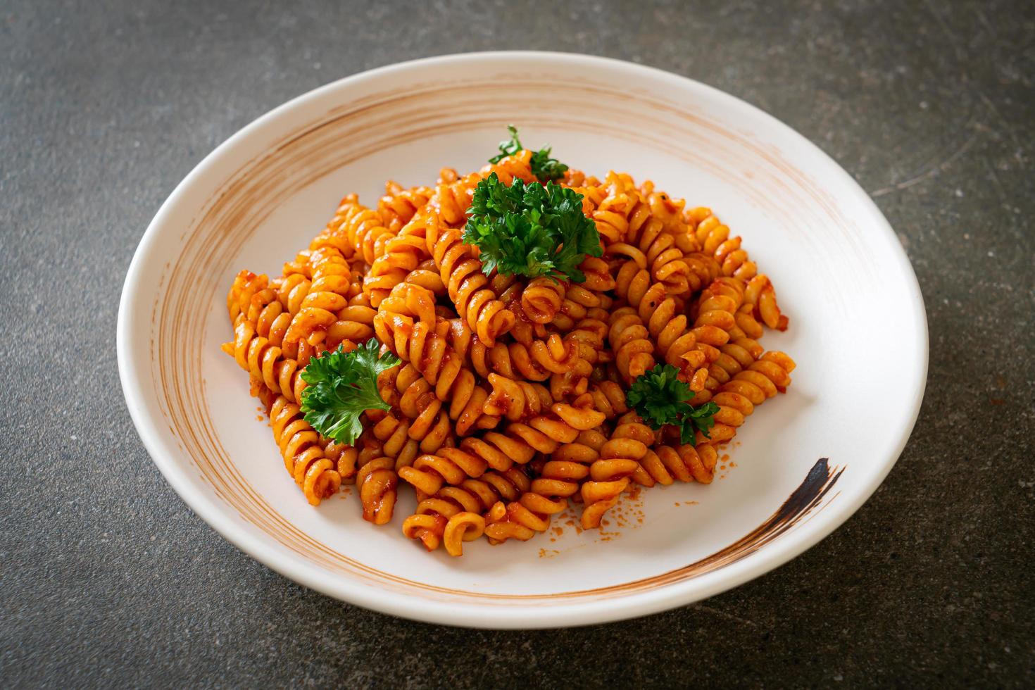 pasta a spirale o spirali con salsa di pomodoro e salsiccia - stile italiano foto